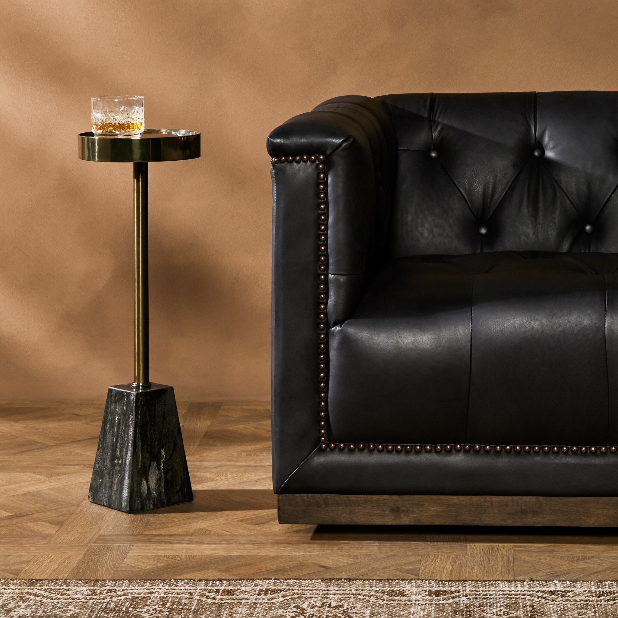Mesa lateral con madera petrificada negro y acero inoxidable Letha en una sala.